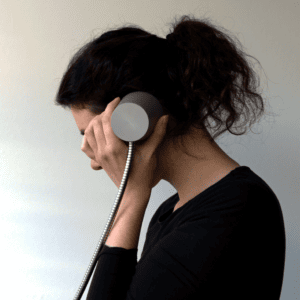 Visitor listening to audio content with single cup earphone